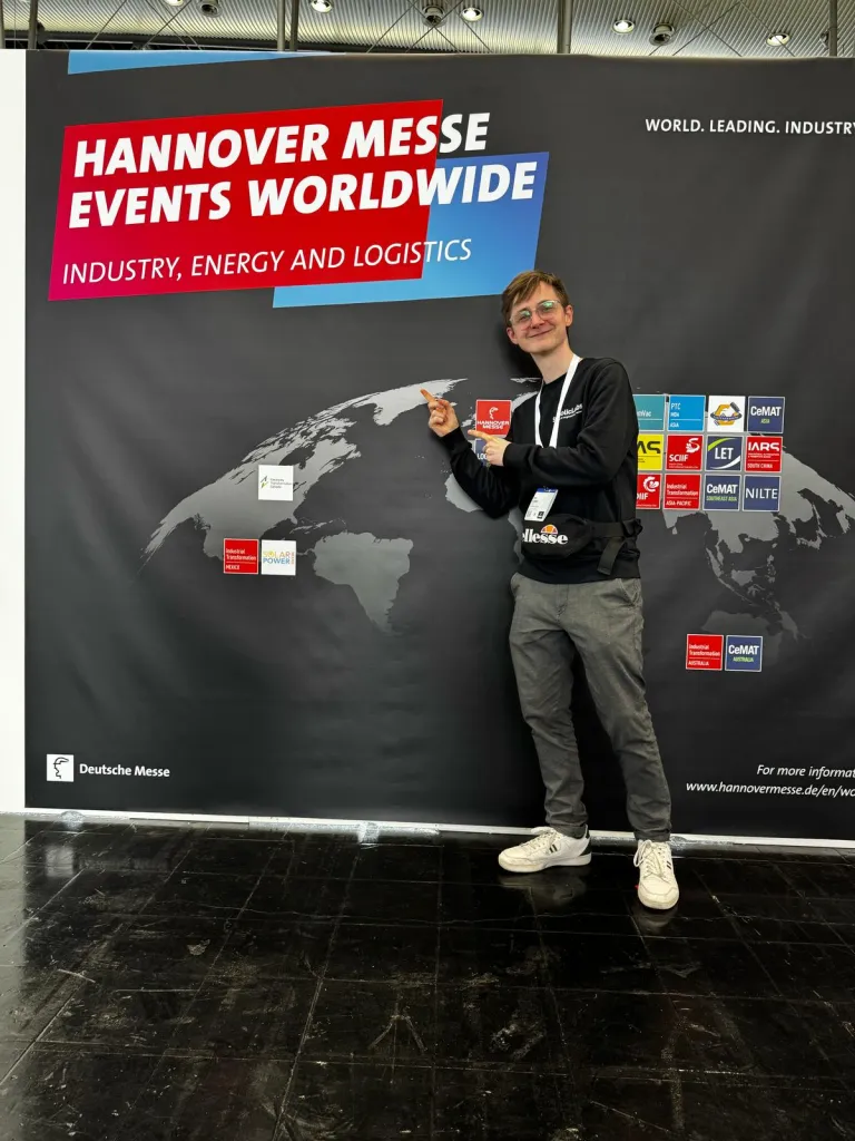 Teammitglied zeigt auf das Hannover Messe Logo auf einer Weltkarte